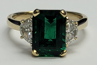 18kt yellow gold emerald and diamond 3-stone ring.