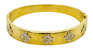 14kt yellow gold wide bangle bracelet with diamond flower style motifs.